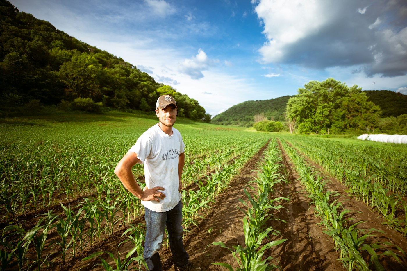 Produtor rural sorrindo na lavoura de milho